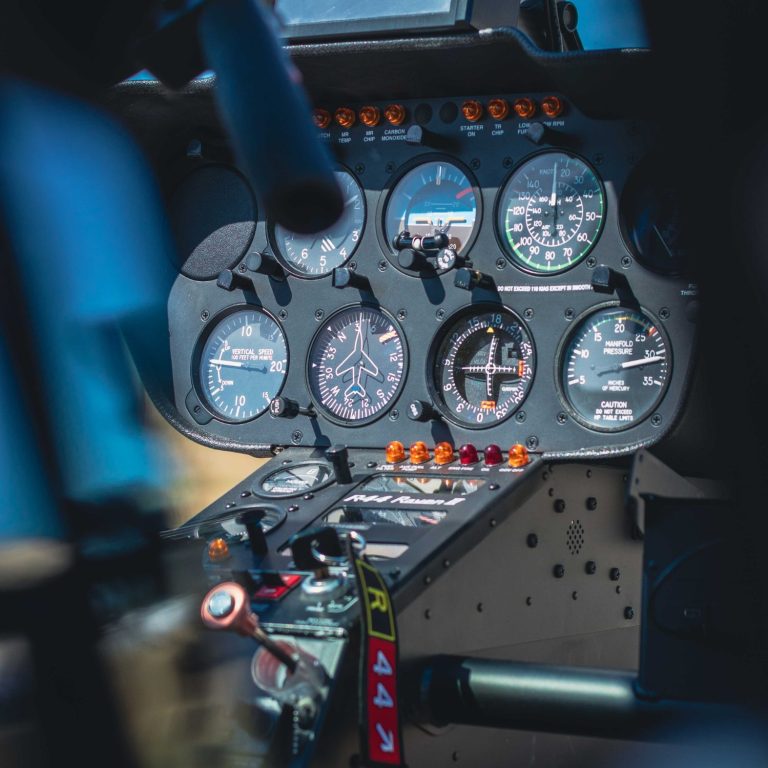 Formation pilote Un pilote d'hélicoptère en tenue professionnelle pris par un passager arrière. Un coucher de soleil est visible ainsi qu'un bord de mer.