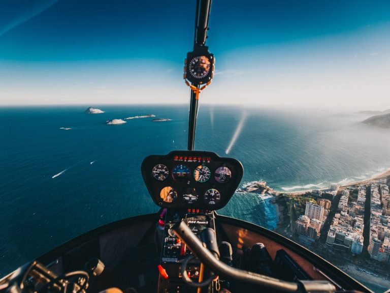 Vue intérieur R44 en vol au dessus d'une mer 