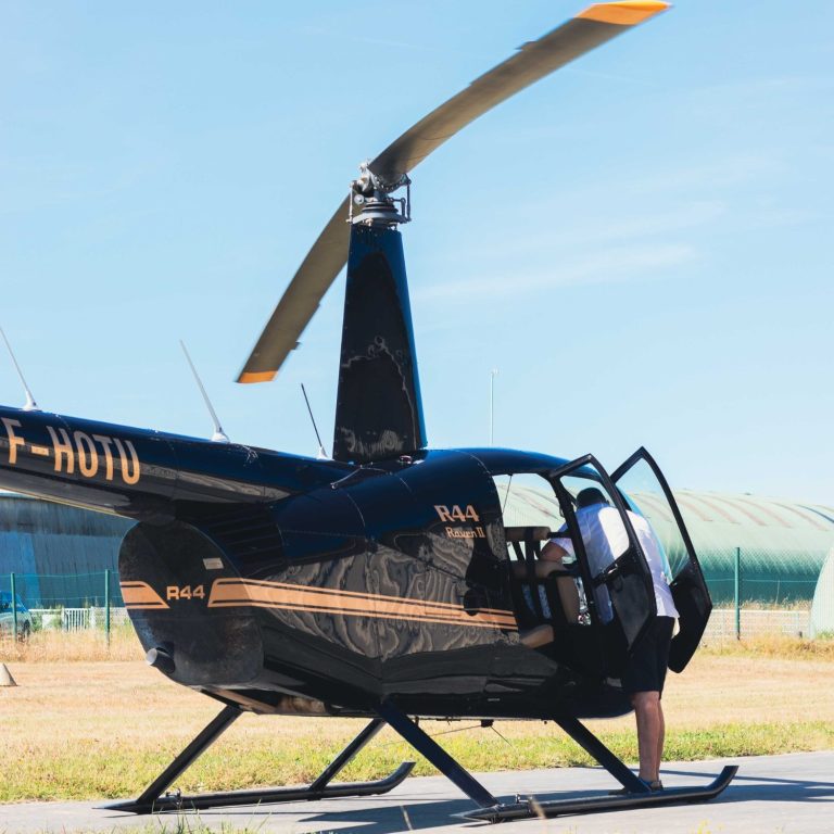 Qualification type R44 Photo d'un hélicoptère R44 blanc vue de trois quart face avec un grand ciel bleu